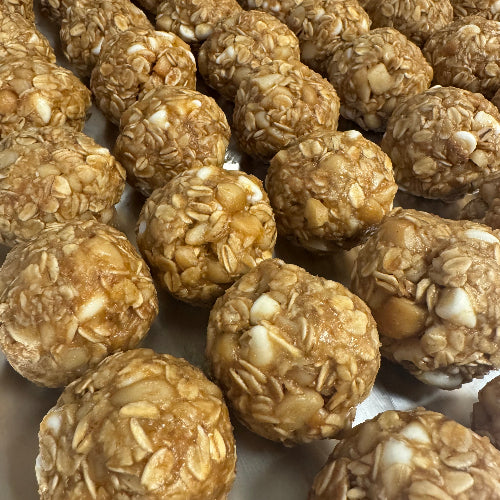 Close-up of energy balls with visible nuts on a white surface